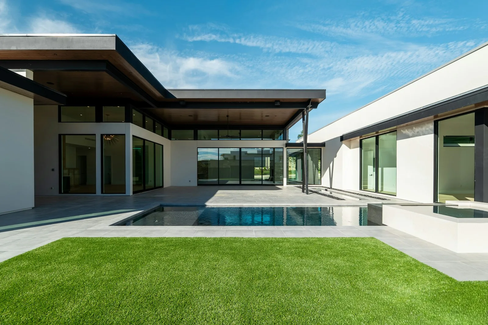 A modern house with a swimming pool and green lawn